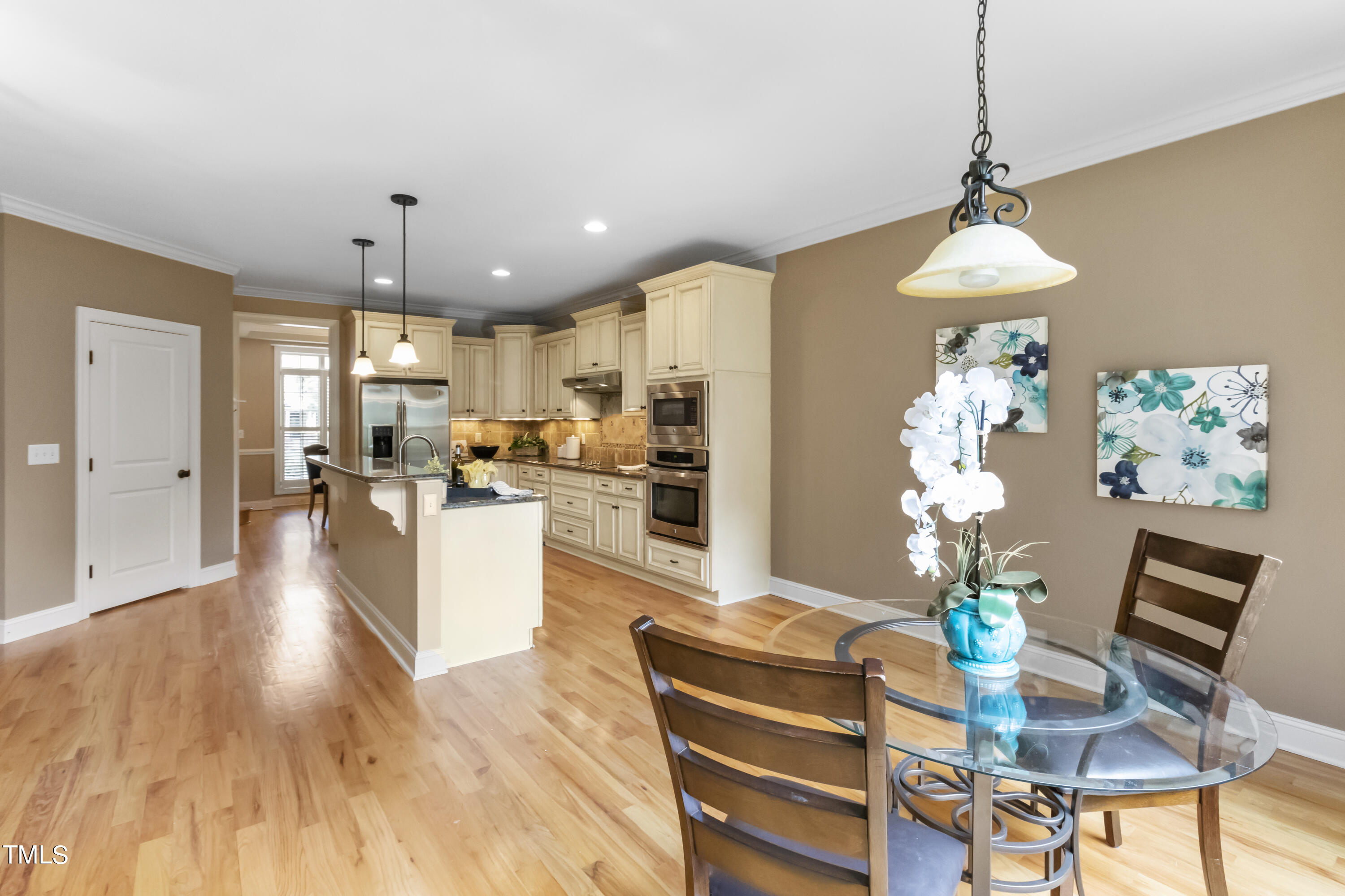 6507 Glendower Road Raleigh, NC 27613 - Photo 6 of 42 a living room with kitchen island furniture and a chandelier