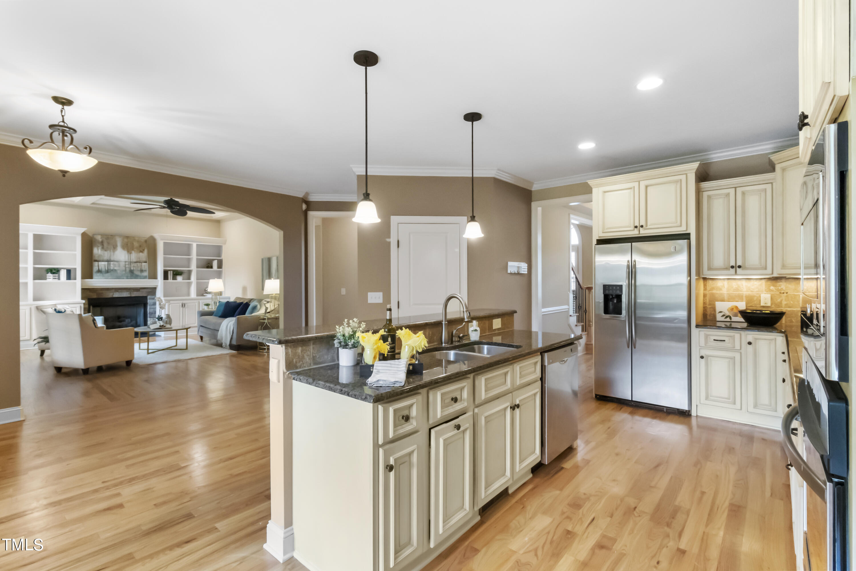 6507 Glendower Road Raleigh, NC 27613 - Photo 8 of 42 a kitchen with stainless steel appliances kitchen island granite countertop a stove refrigerator and wooden floor