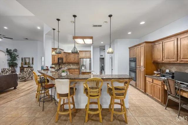 a kitchen with stainless steel appliances granite countertop a refrigerator a sink dishwasher a stove with white cabinets