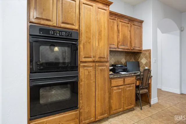 a kitchen with stainless steel appliances granite countertop a sink a stove a refrigerator and a granite counter tops