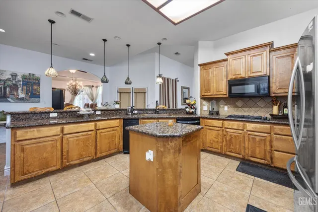 a bedroom with a bed a flat screen tv and dresser