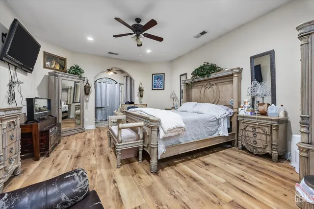 a bedroom with a bed a flat screen tv and dresser