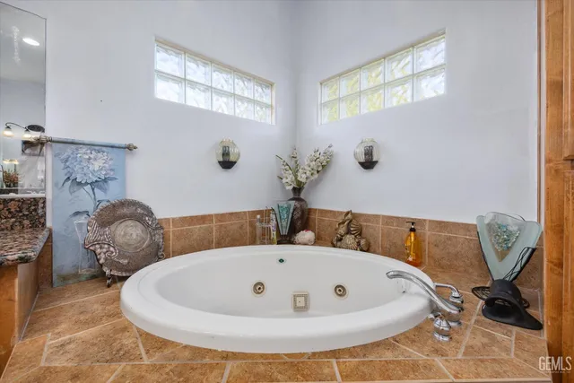 a bathroom with a tub a sink and mirror