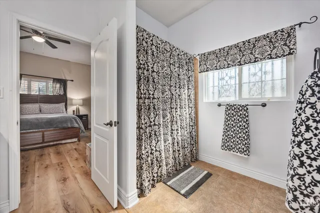 a bedroom with a bed a dresser with wooden floor