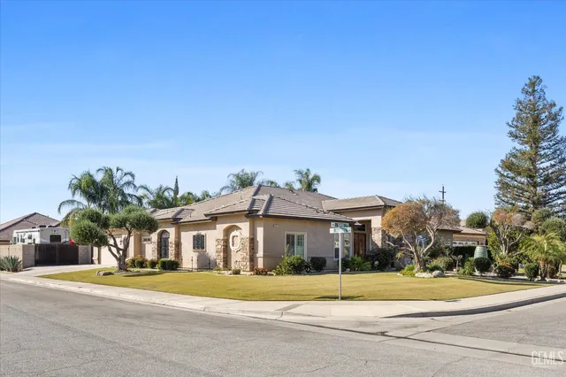 a front view of residential houses with yard and trees