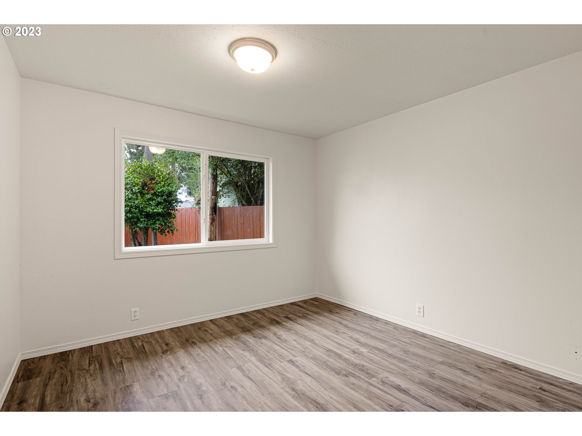 1833 North 12th Street Springfield, OR 97477 - Photo 18 of 37 a view of an empty room with wooden floor and a window