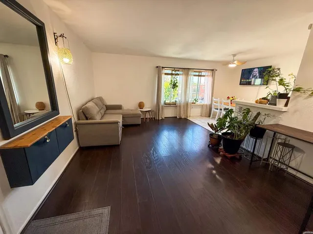 a living room with furniture and a wooden floor