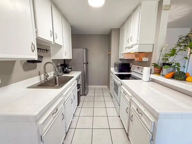 a kitchen with a sink a stove and cabinets
