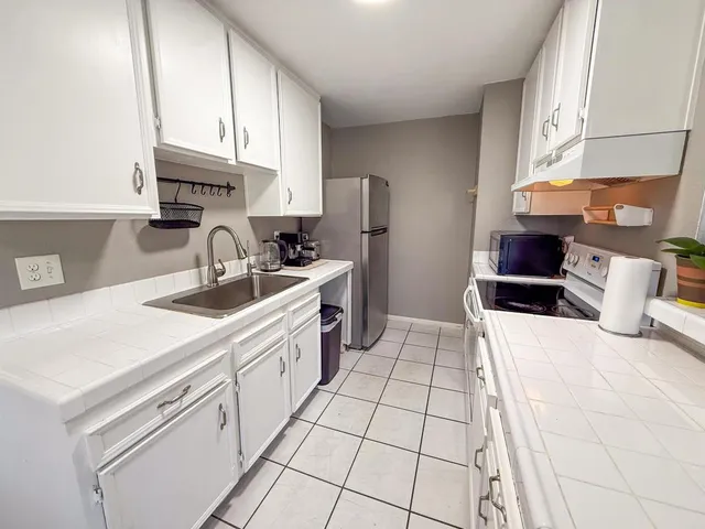 a kitchen with a sink a stove and a refrigerator