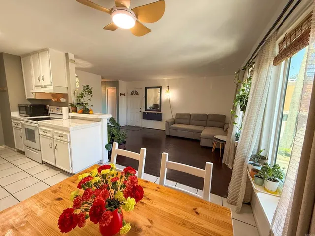 a living room with stainless steel appliances furniture and a view of kitchen