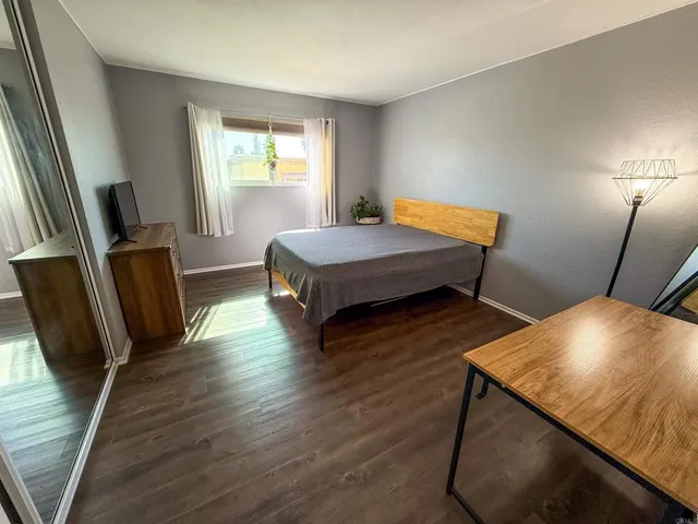 a bedroom with wooden floors and a bed