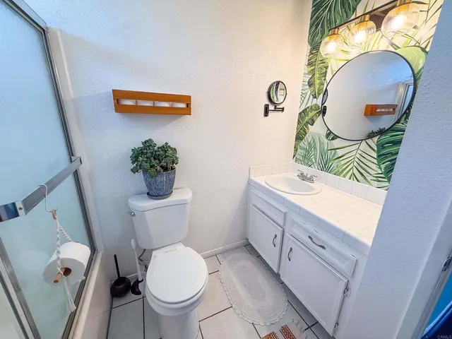a bathroom with a toilet a sink and a mirror