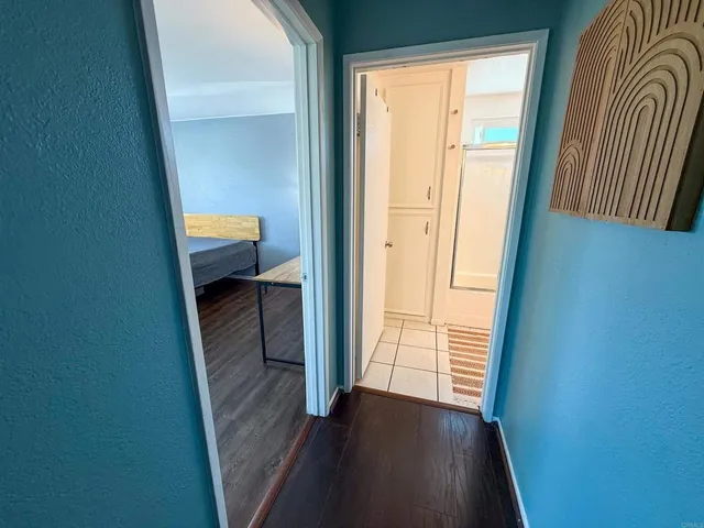 a view of a hallway with wooden floor and a closet