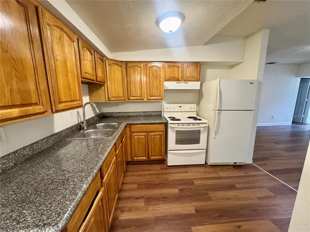 a kitchen with stainless steel appliances granite countertop a stove a sink and a refrigerator