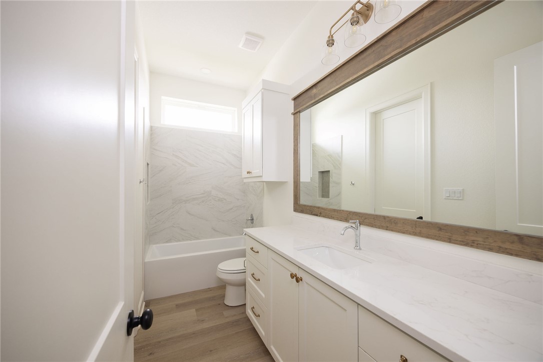6697 Ridgeview Estates Lane Bryan, TX 77808 - Photo 27 of 31 a bathroom with a bathtub shower sink mirror vanity and a toilet