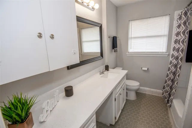 a bathroom with a sink a toilet and window