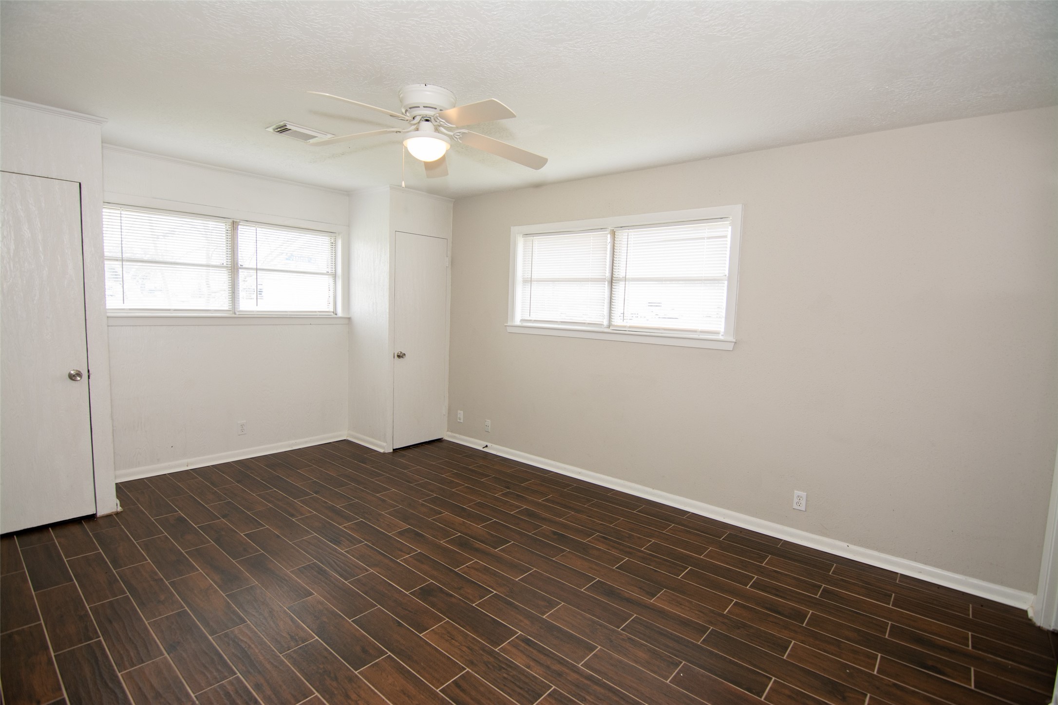 103 East Janisch Road Houston, TX 77022 - Photo 14 of 18 an empty room with wooden floor and windows