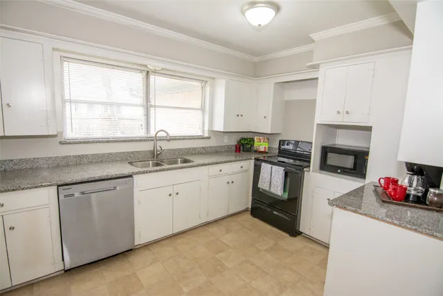 a kitchen with granite countertop white cabinets and white appliances