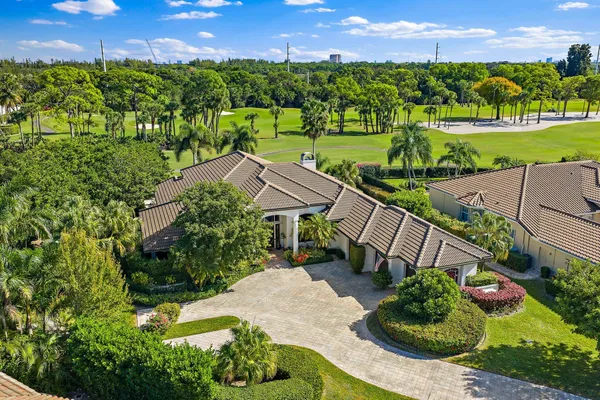 an aerial view of a house with a garden and lake view
