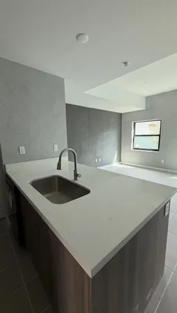 a kitchen with a sink a stove and cabinets