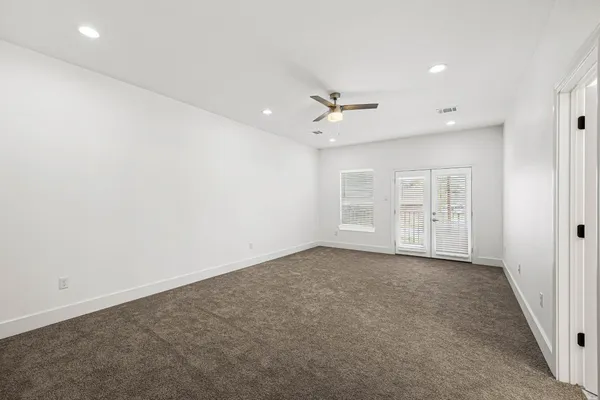 an empty room with closet and a ceiling fan
