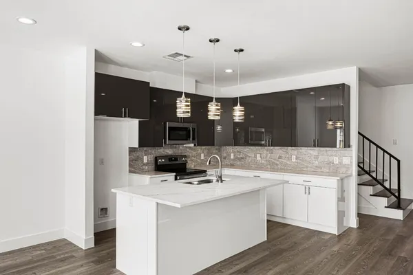 a kitchen with a sink cabinets and wooden floor