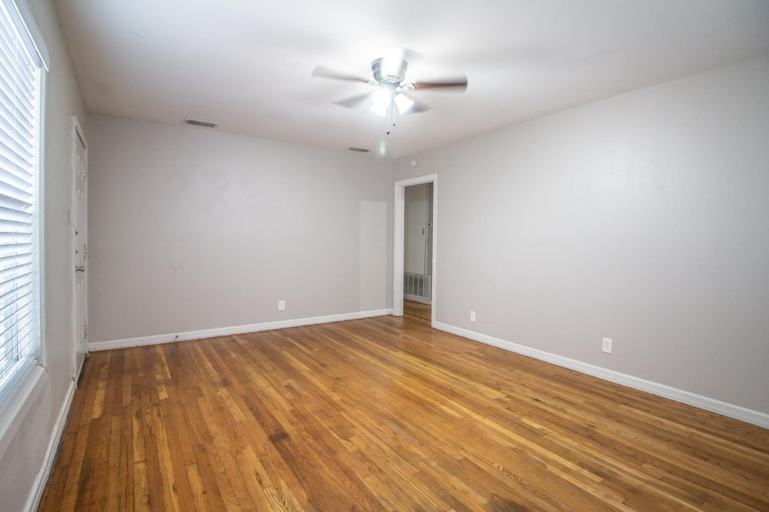 2715 36th Street Lubbock, TX 79413 - Photo 3 of 14 wooden floor in an empty room with a window