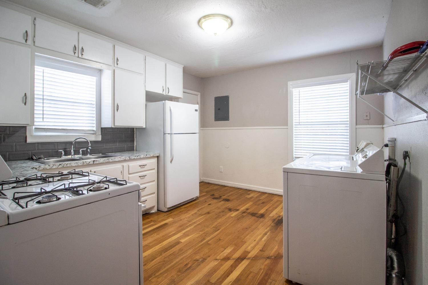 2715 36th Street Lubbock, TX 79413 - Photo 4 of 14 a kitchen with a refrigerator a stove top oven a counter space and a window