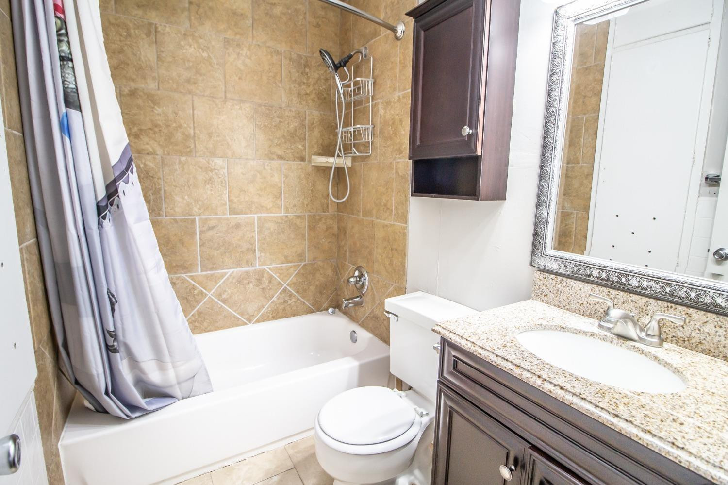 2715 36th Street Lubbock, TX 79413 - Photo 9 of 14 a bathroom with a granite countertop sink toilet and shower