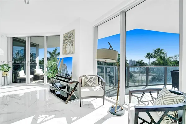 a living room with furniture a floor to ceiling window and a table