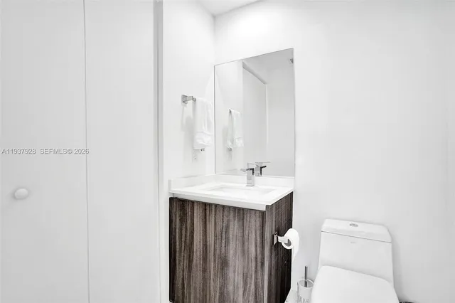 a bathroom with a toilet a sink and mirror