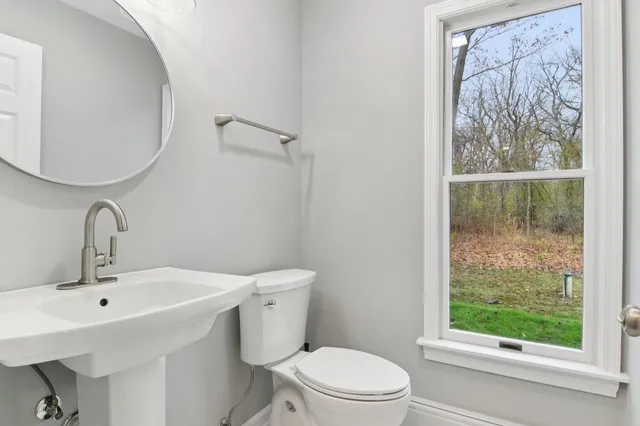 a bathroom with a sink a toilet and a mirror