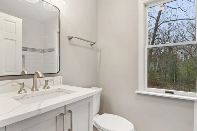 a bathroom with a granite countertop sink and a mirror