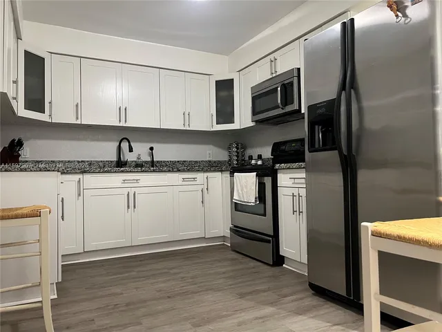 a kitchen with stainless steel appliances granite countertop a refrigerator sink and stove