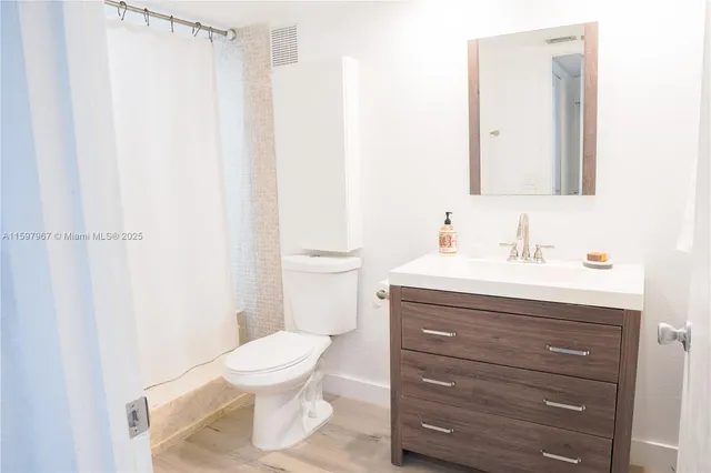a bathroom with a toilet a sink and a mirror