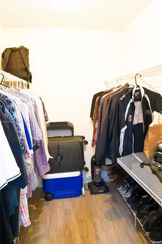 a view of walk in closet with clothes and shoes