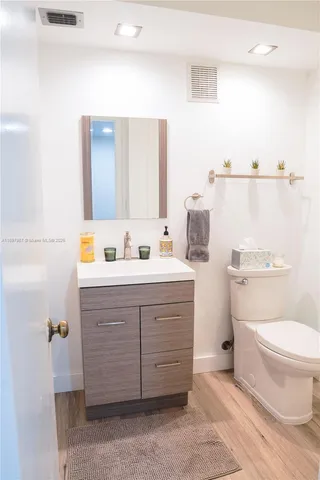 a bathroom with a sink toilet vanity and mirror