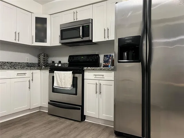 a kitchen with white cabinets and stainless steel appliances