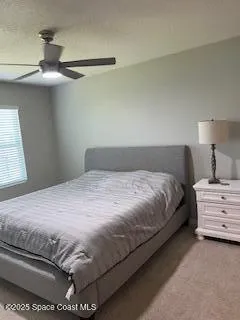a bedroom with a bed and a ceiling fan