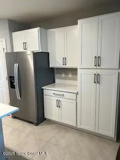 a kitchen with a refrigerator sink and cabinets