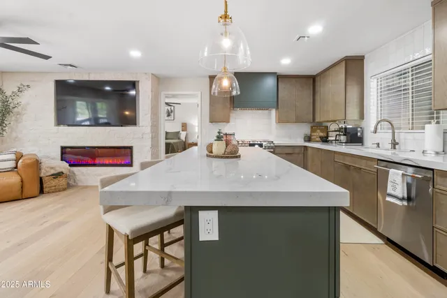 a kitchen with kitchen island stainless steel appliances sink microwave and stove