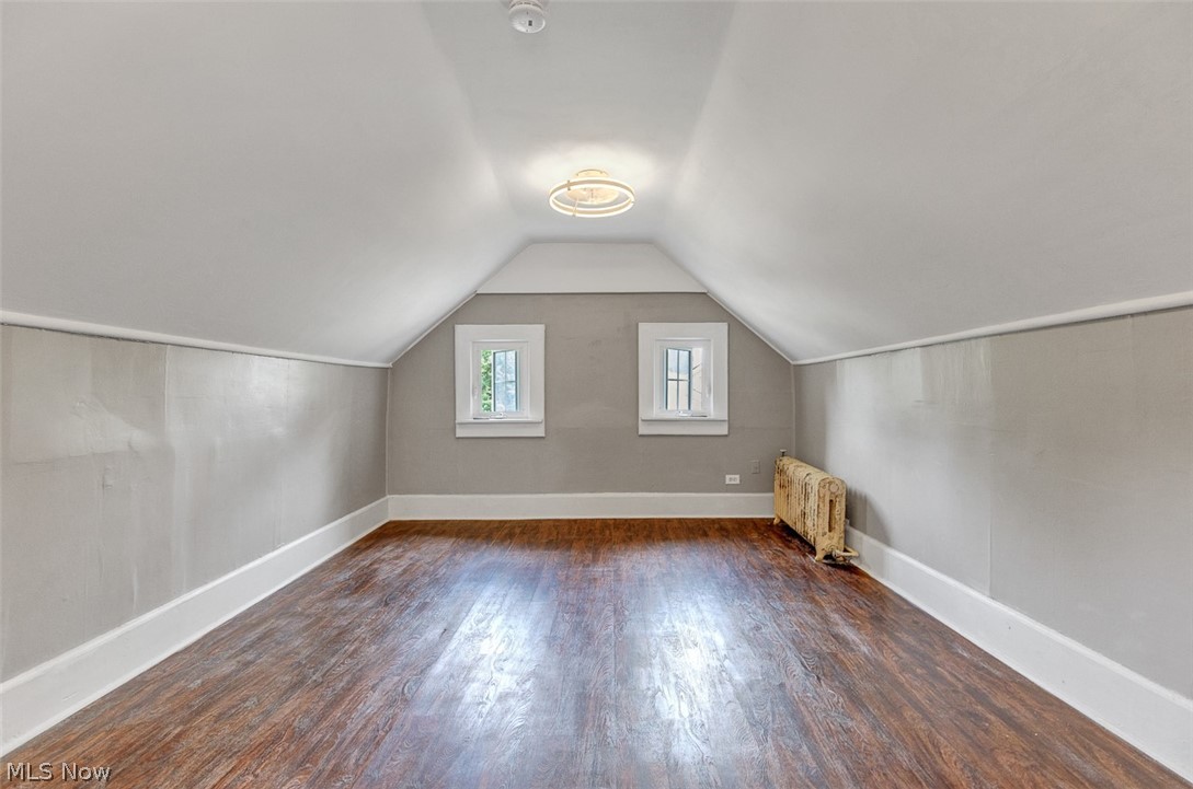2972 Yorkshire Road Cleveland Heights, OH 44118 - Photo 20 of 44 Room featuring wood-finish flooring, two window openings, a ceiling-mounted light fixture, and a cast-iron radiator