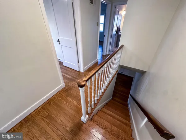 a view of staircase with wooden floor and white walls