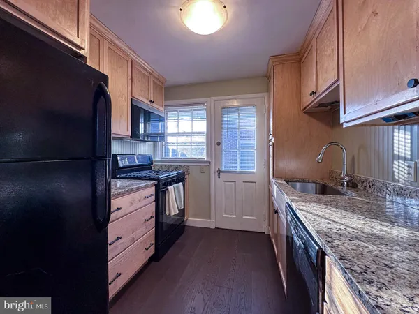a kitchen with stainless steel appliances granite countertop a refrigerator a stove and a sink