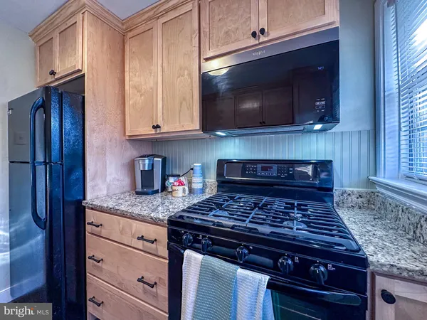 a kitchen with granite countertop a stove and a microwave