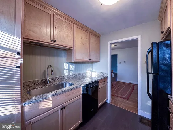 a kitchen with granite countertop stainless steel appliances and wooden cabinets