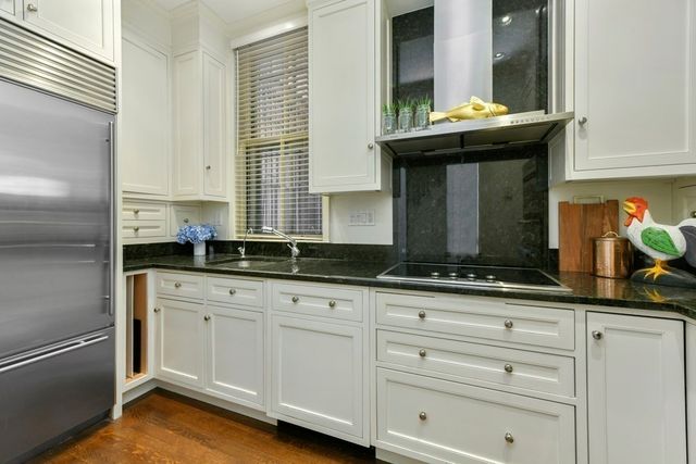 a kitchen with stainless steel appliances granite countertop a sink and cabinets with wooden floor