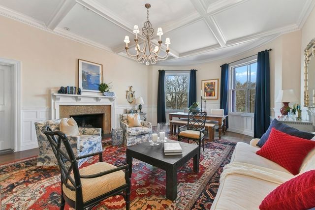 a living room with furniture a chandelier and a fireplace