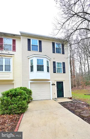 a front view of a house with a garden and garage