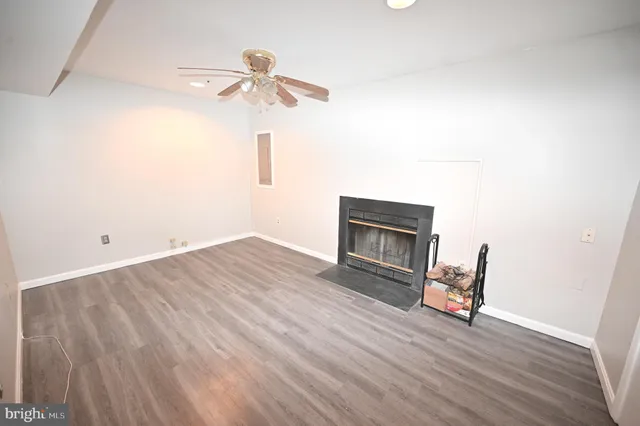 a view of a livingroom with wooden floor and chairs